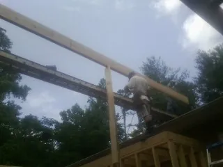 Carpenter setting a ridge beam over a new addition frame — Ice Dam Removal by Roofing Brothers in Mohnton