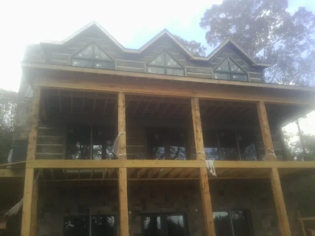 Dormers and porch framing on a large log home under construction — Roof Coating work by our crew in Mohnton
