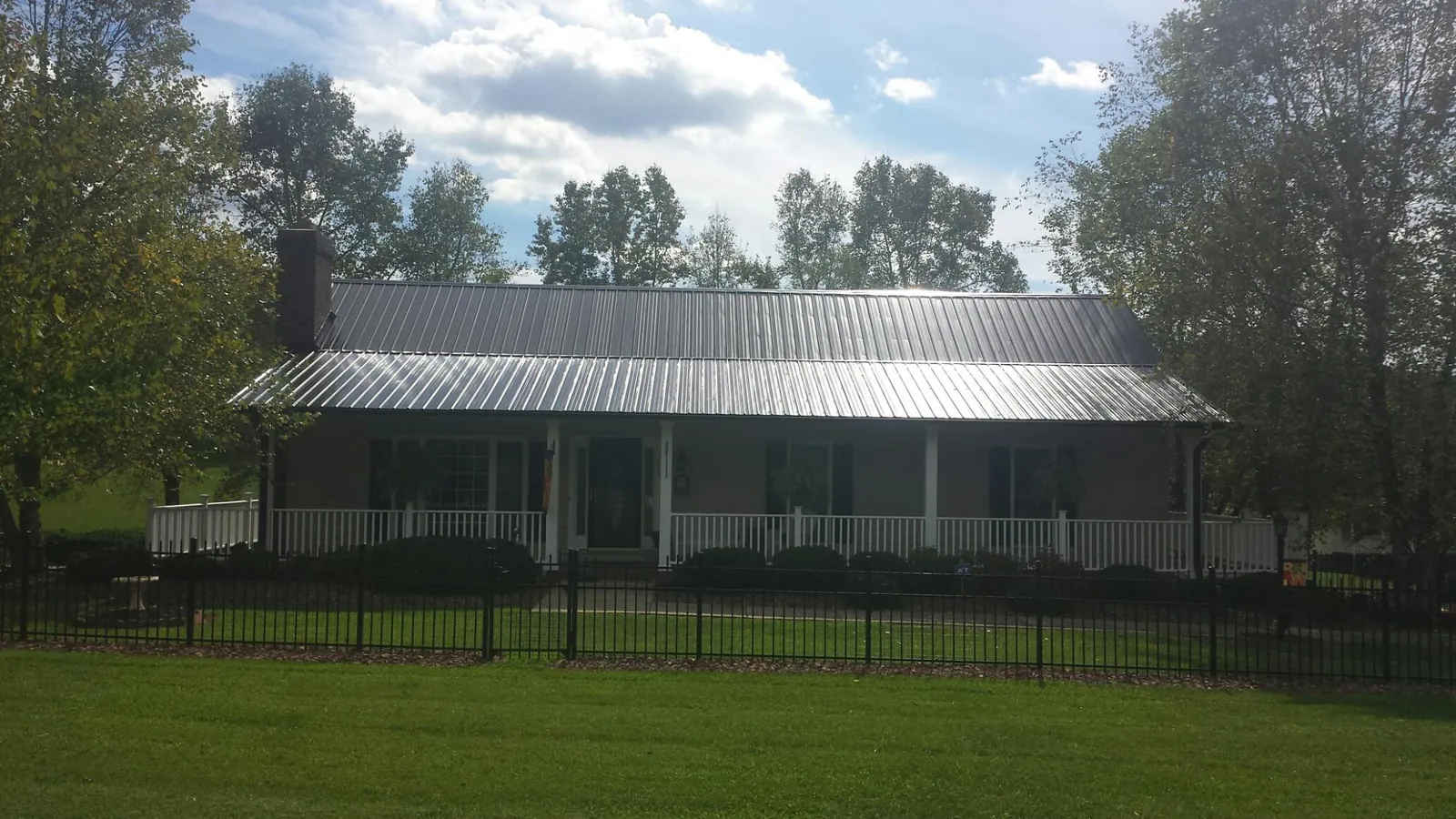 Gray metal roof on a brick ranch with a full width front porch — Gutter Guard Installation work by our crew in Mohnton