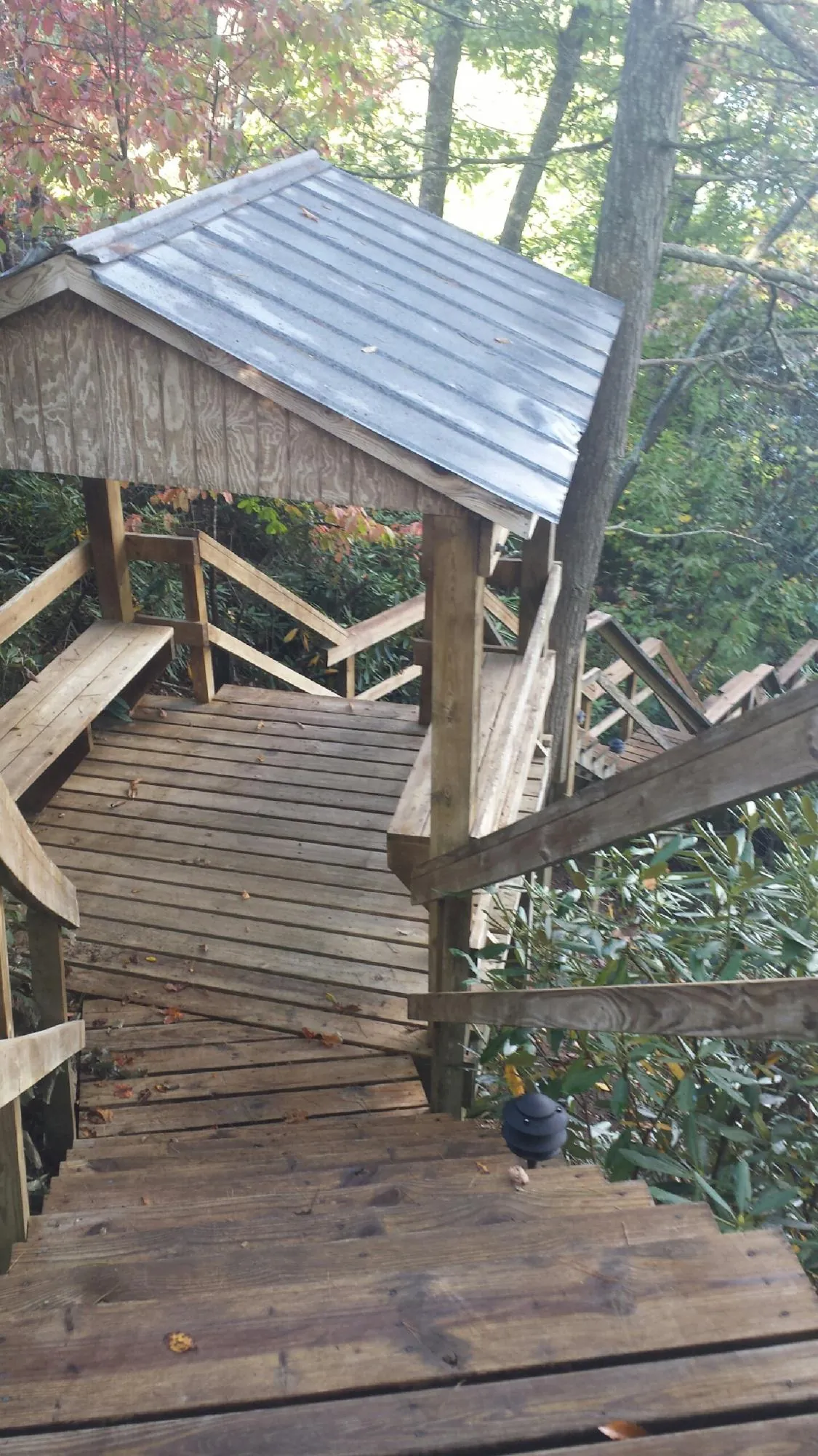 Metal roofed shelter over wooden steps on a wooded walkway — Skylight Repair & Installation work by our crew in Mohnton